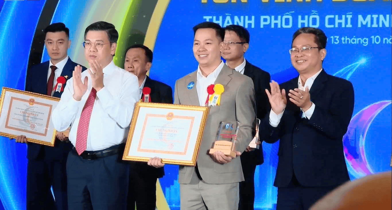 Lãnh đạo thành phố vỗ tay khi ông Trần Thiên Ấn cầm chứng nhận và cúp trên sân khấu